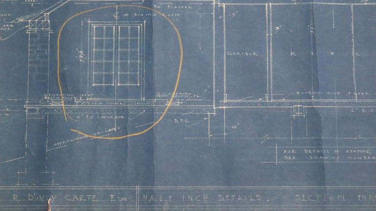 Archive blueprint detailing a window design with measurements and annotations, framed in a circular highlight on a blue background.